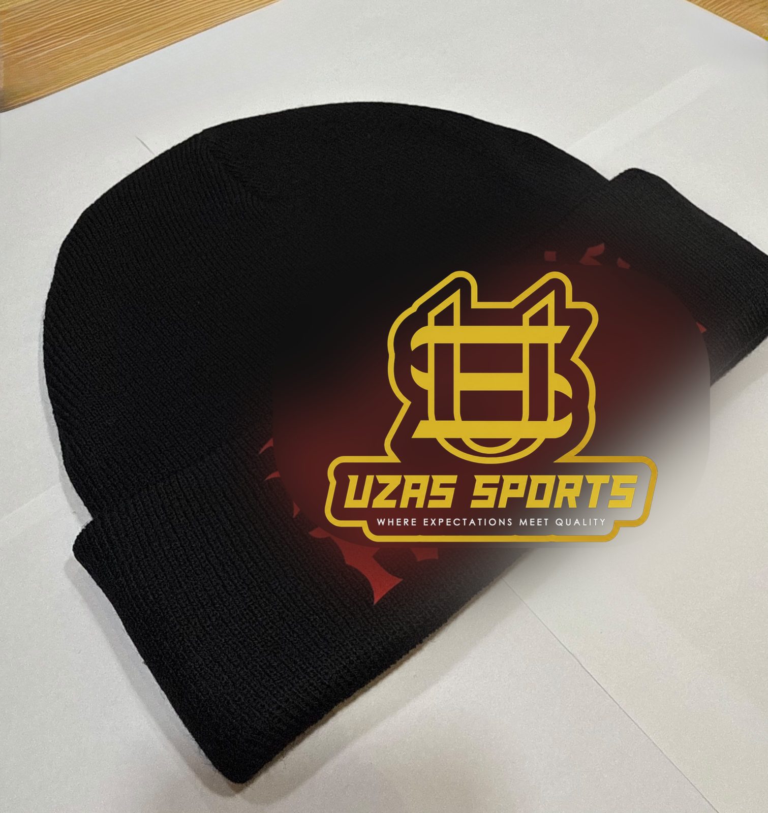 Black cuffed beanie with an embroidered logo made by UZAS Sports (customer logo replaced)
