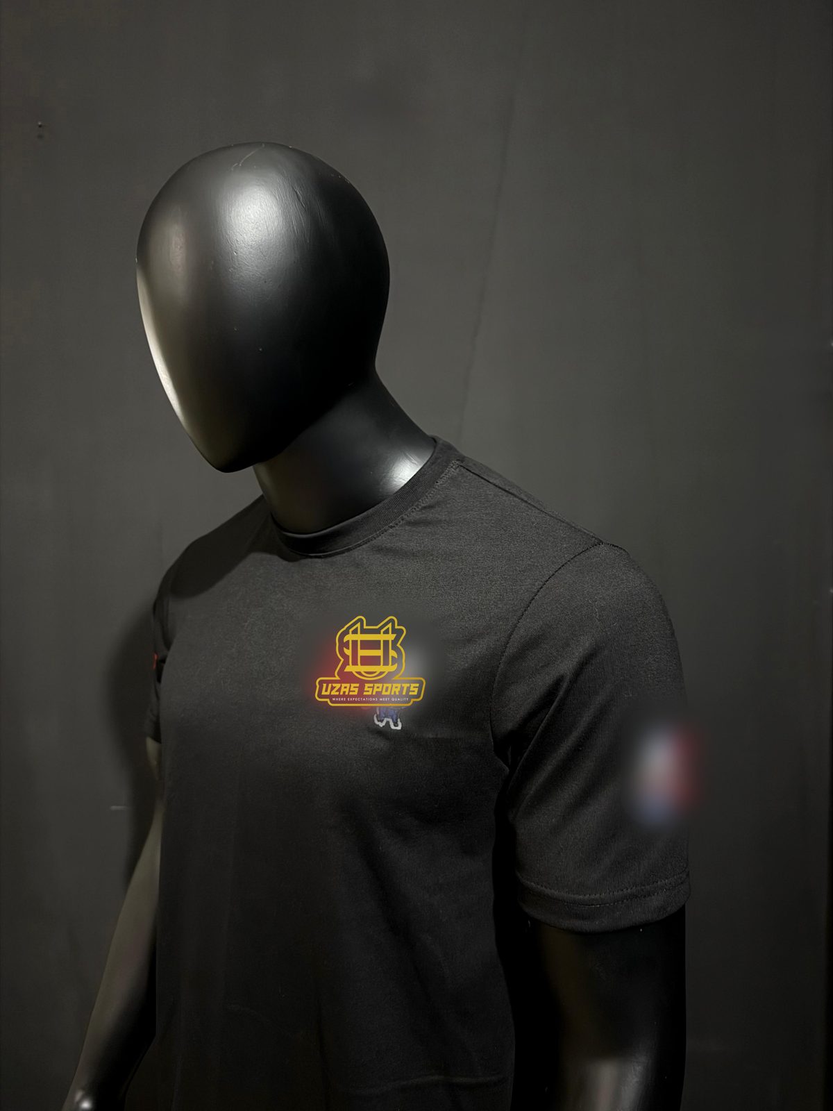 Black crew-neck t-shirt with a printed chest logo made by UZAS Sports (customer logo replaced)