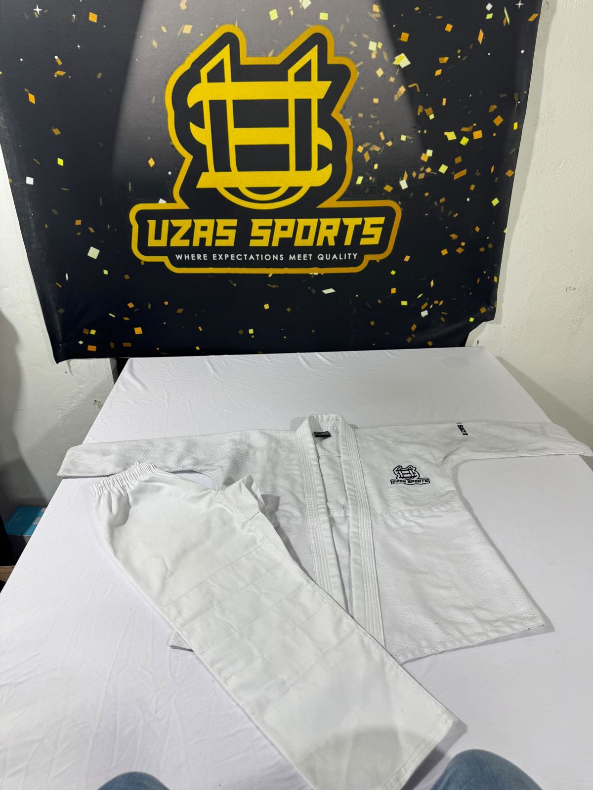 White karate gi laid out for checking at the UZAS Sports factory
