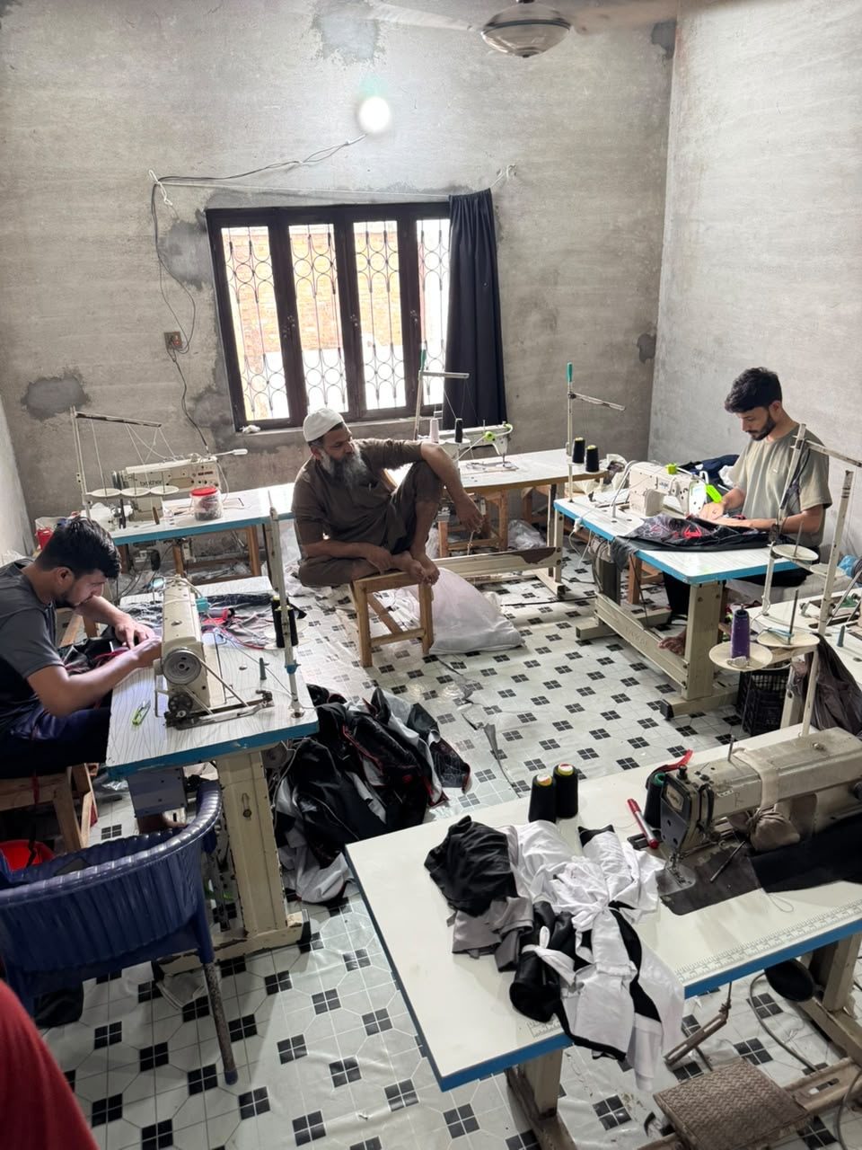 Machinists stitching garments on the UZAS Sports sewing floor in Sialkot